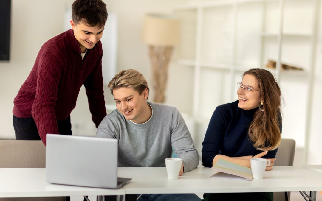 Troje młodych ludzi przy laptopie.